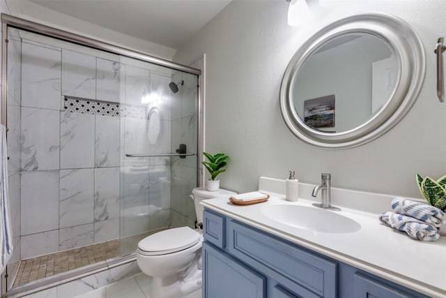 bathroom with vanity, toilet, and a shower with door