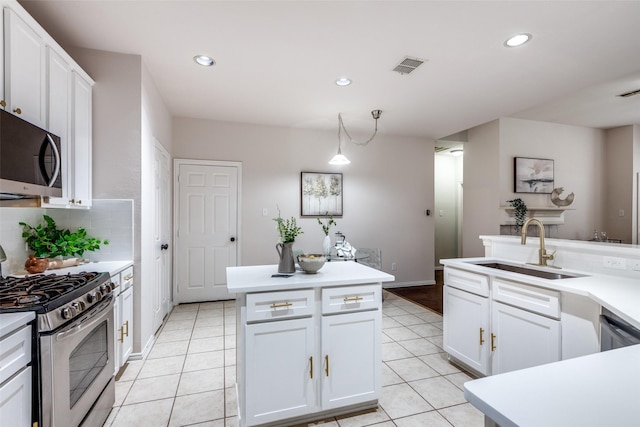 kitchen with white cabinetry, sink, hanging light fixtures, light tile patterned floors, and appliances with stainless steel finishes