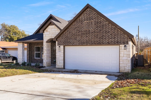 view of front of home with central AC unit and a garage