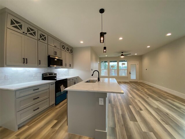 kitchen featuring gray cabinetry, hanging light fixtures, range with electric stovetop, and sink