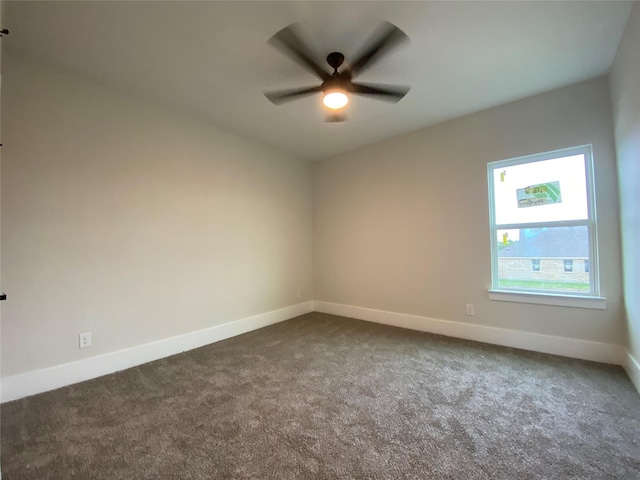 spare room featuring ceiling fan and dark colored carpet