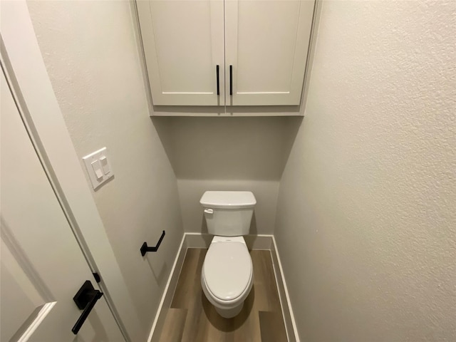 bathroom with toilet and hardwood / wood-style floors