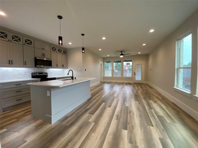 kitchen featuring electric stove, decorative light fixtures, sink, and gray cabinetry