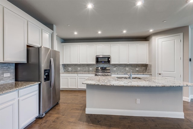 kitchen featuring white cabinets, stainless steel appliances, a center island with sink, and sink