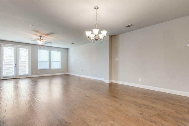 spare room featuring ceiling fan with notable chandelier and hardwood / wood-style flooring