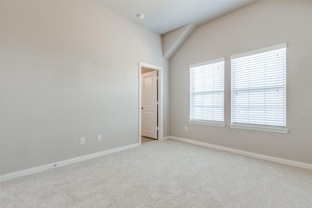 carpeted spare room featuring lofted ceiling