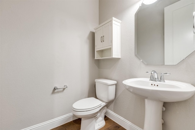 bathroom with sink, hardwood / wood-style floors, and toilet