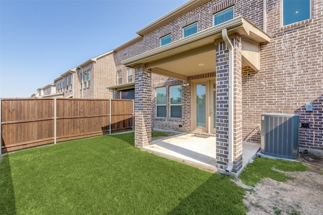 back of house featuring central AC, a yard, and a patio area