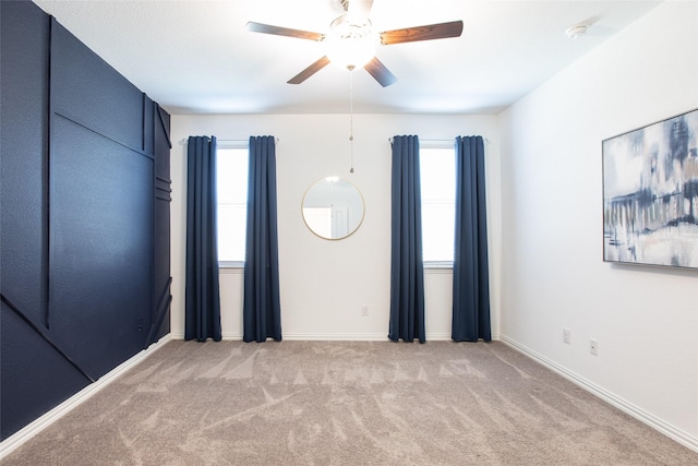 empty room with plenty of natural light, light carpet, and ceiling fan