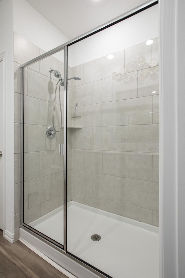 bathroom with hardwood / wood-style floors and a shower with door