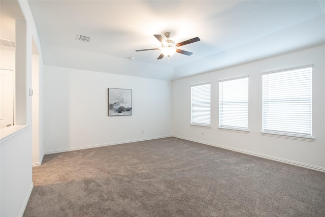 unfurnished room with carpet flooring, a raised ceiling, and ceiling fan