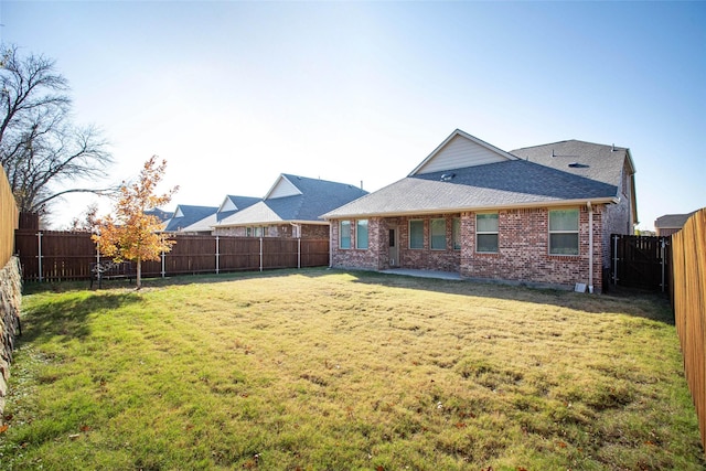 rear view of house featuring a yard