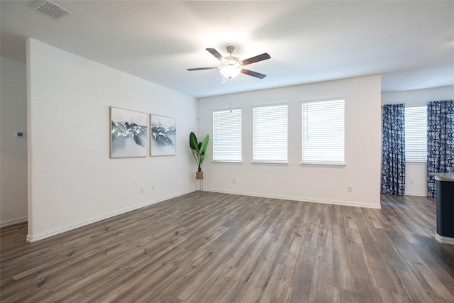 unfurnished room featuring dark wood-type flooring and ceiling fan