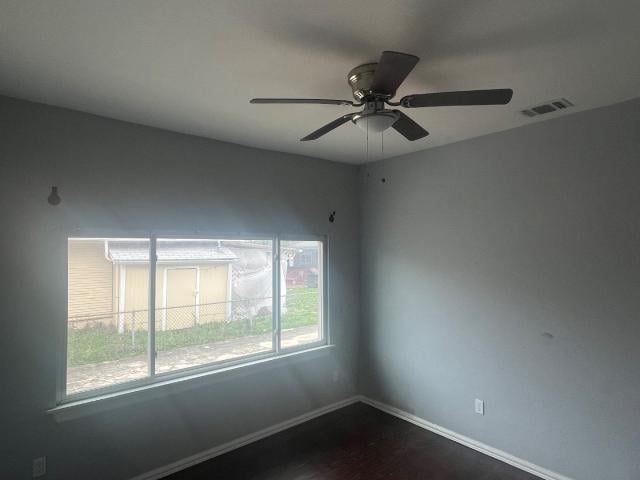 unfurnished room featuring ceiling fan and dark wood-type flooring