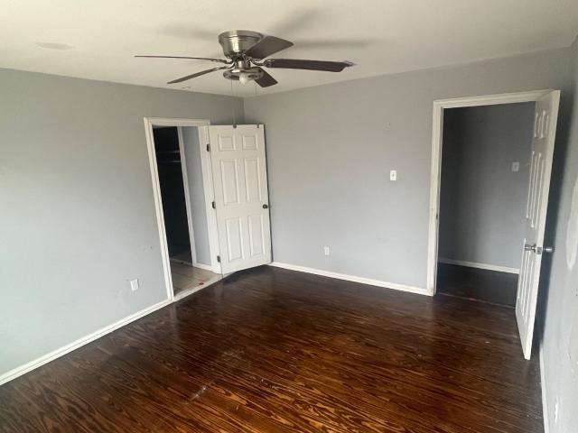 empty room with dark hardwood / wood-style floors and ceiling fan