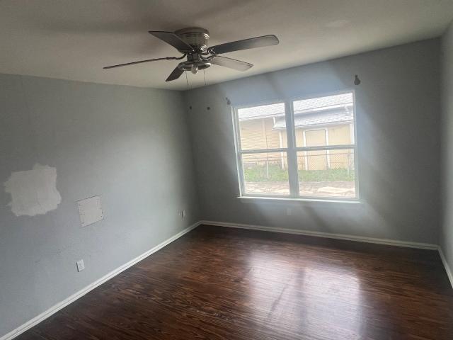 unfurnished room with dark hardwood / wood-style floors and ceiling fan