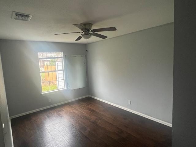 unfurnished room with dark hardwood / wood-style flooring and ceiling fan