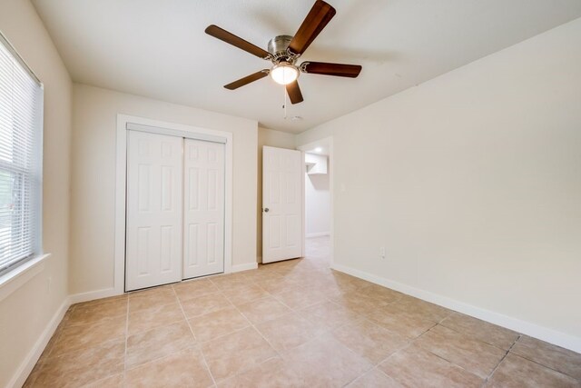 unfurnished bedroom featuring a closet, ceiling fan, and light tile patterned flooring