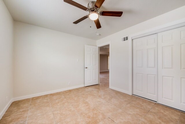 unfurnished bedroom featuring light tile patterned floors, ceiling fan, and a closet