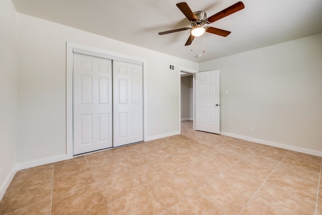 unfurnished bedroom with light tile patterned flooring, ceiling fan, and a closet