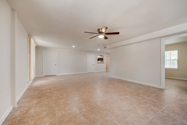 tiled spare room featuring ceiling fan