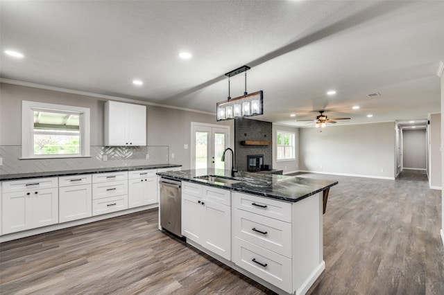 kitchen featuring ceiling fan, a kitchen island with sink, sink, dishwasher, and white cabinetry