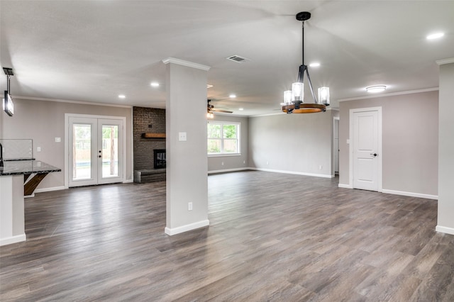 unfurnished living room featuring a fireplace, dark hardwood / wood-style flooring, ceiling fan, and ornamental molding