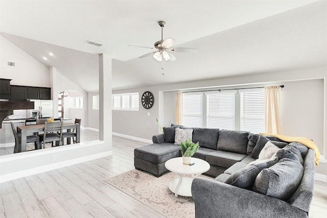 living room featuring ceiling fan, a healthy amount of sunlight, light wood-type flooring, and vaulted ceiling