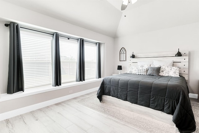 bedroom with ceiling fan, light hardwood / wood-style flooring, and lofted ceiling