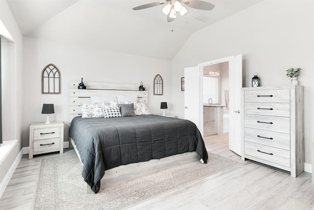 bedroom with ceiling fan, light hardwood / wood-style floors, lofted ceiling, and connected bathroom