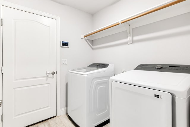 washroom featuring washer and clothes dryer and light hardwood / wood-style flooring