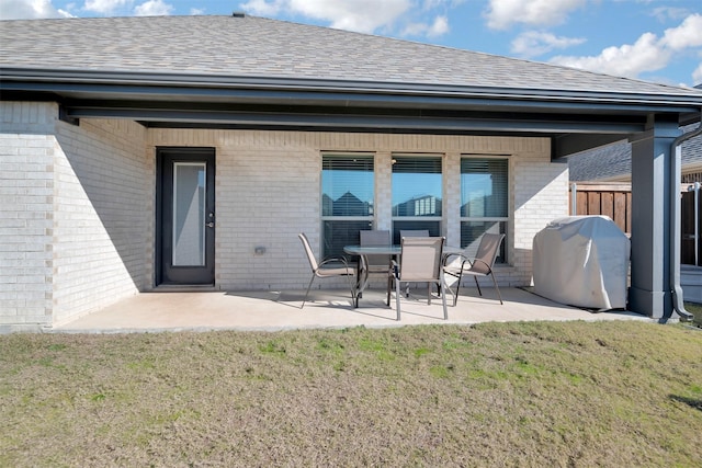 rear view of property with a lawn and a patio