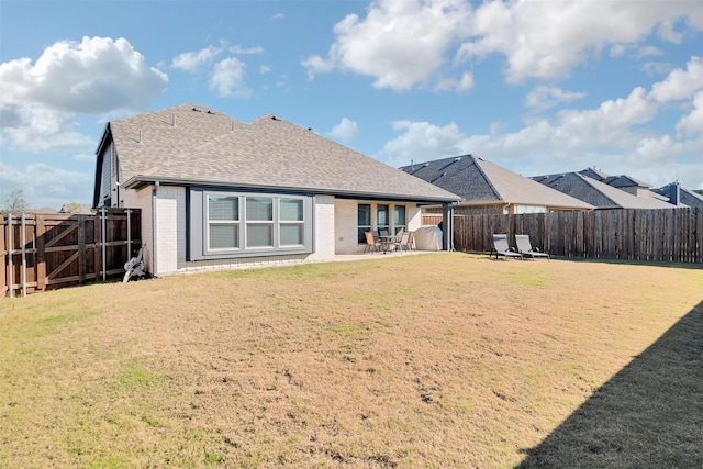 rear view of house featuring a yard and a patio