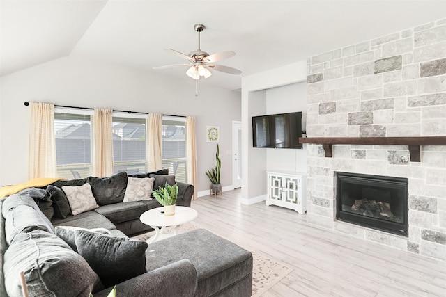 living room with a fireplace, light wood-type flooring, ceiling fan, and lofted ceiling