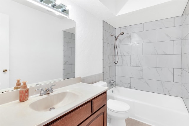 full bathroom featuring tile patterned floors, vanity, tiled shower / bath, and toilet