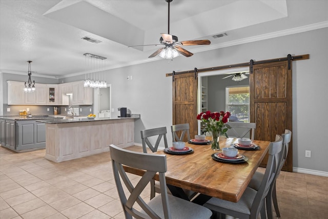 dining room with a barn door, light tile patterned flooring, and ornamental molding