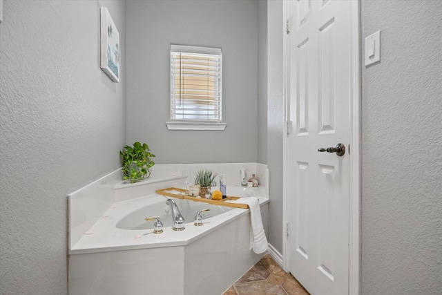 bathroom with tile patterned flooring and a bath