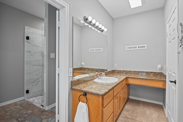 bathroom featuring vanity, an enclosed shower, and a skylight