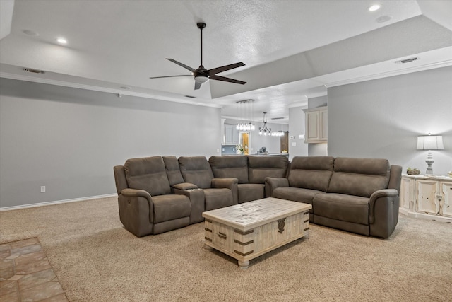 carpeted living room with a tray ceiling and ceiling fan