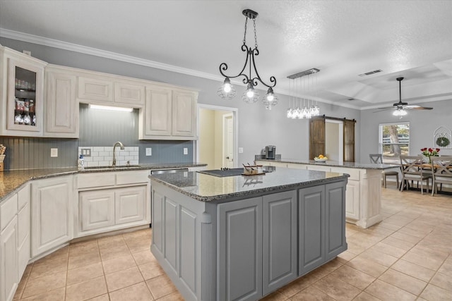 kitchen featuring a center island, a barn door, sink, and pendant lighting