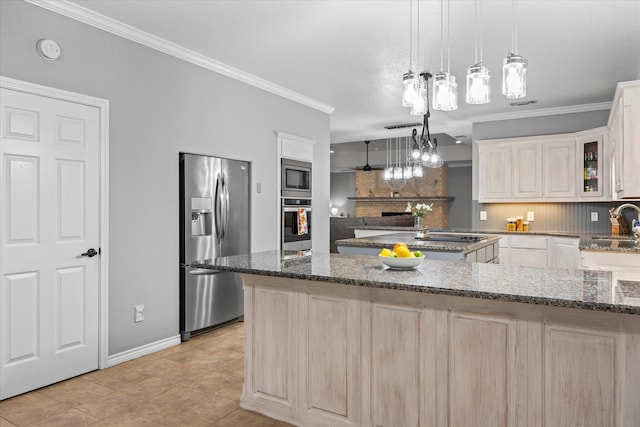 kitchen with pendant lighting, backsplash, dark stone counters, light tile patterned floors, and appliances with stainless steel finishes