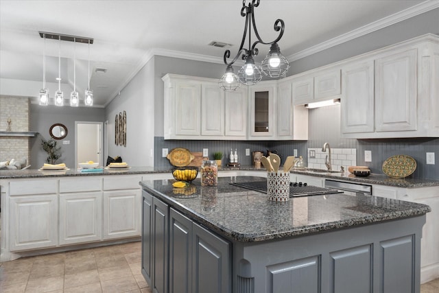 kitchen with black electric stovetop, sink, white cabinets, and a kitchen island