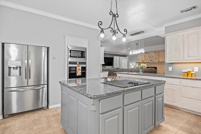 kitchen featuring appliances with stainless steel finishes, a center island, white cabinetry, and light stone counters