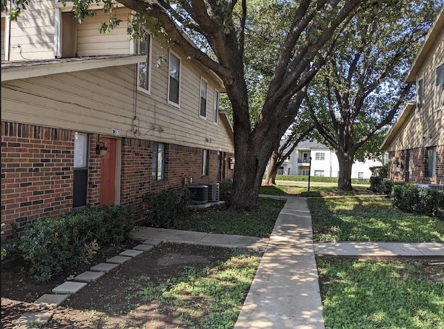 view of side of property featuring a yard and cooling unit