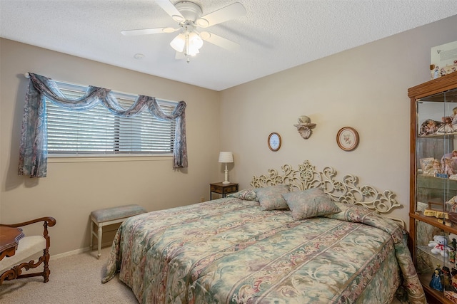 bedroom featuring ceiling fan, light colored carpet, and a textured ceiling