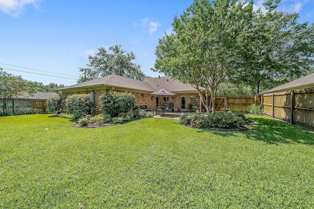 rear view of property with a patio and a lawn