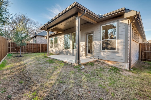 back of property featuring a patio area and a yard