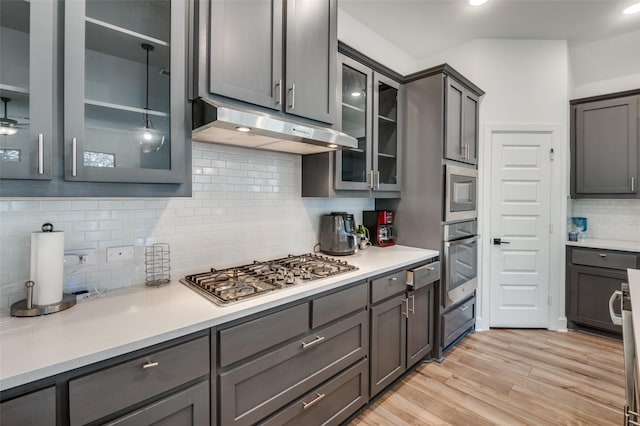 kitchen featuring ceiling fan, backsplash, gray cabinetry, light hardwood / wood-style floors, and stainless steel appliances