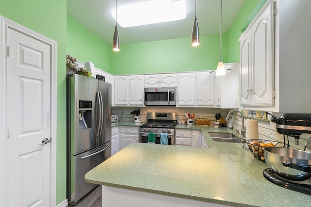 kitchen featuring white cabinetry, sink, kitchen peninsula, pendant lighting, and appliances with stainless steel finishes