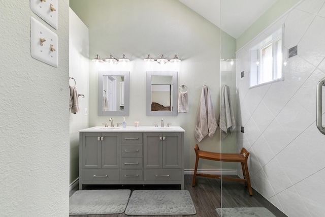 bathroom with hardwood / wood-style floors, vanity, and an enclosed shower